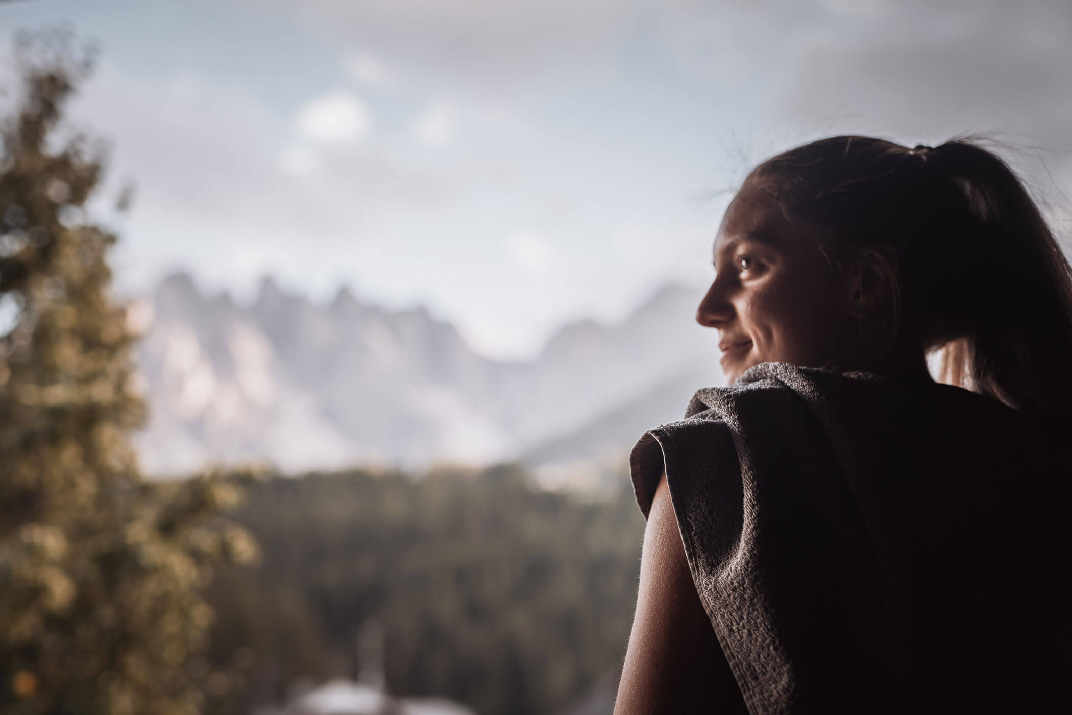 Eine Frau auf dem Balkon blickt in die Ferne