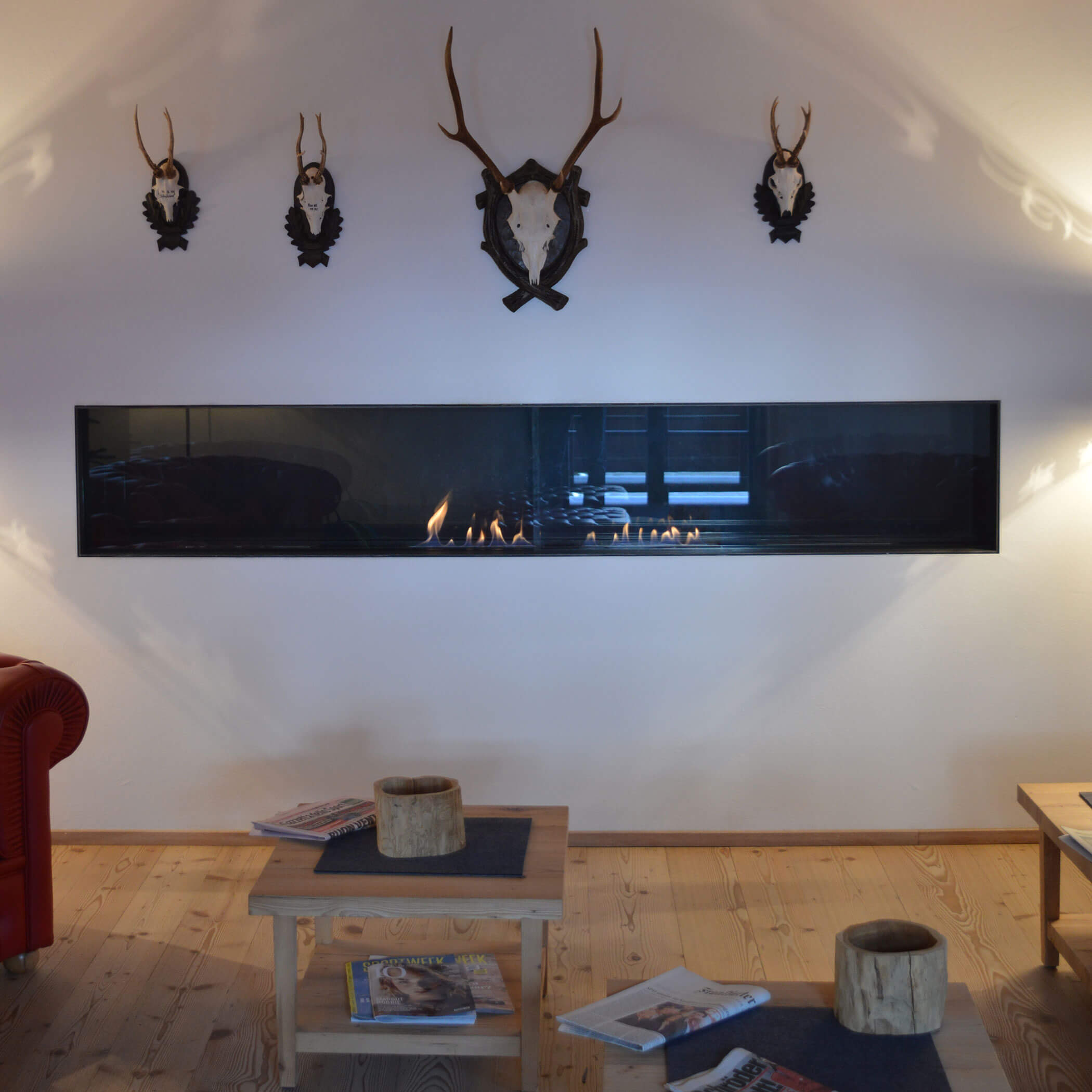 Kaminfeuer und Geweihe an der Wand