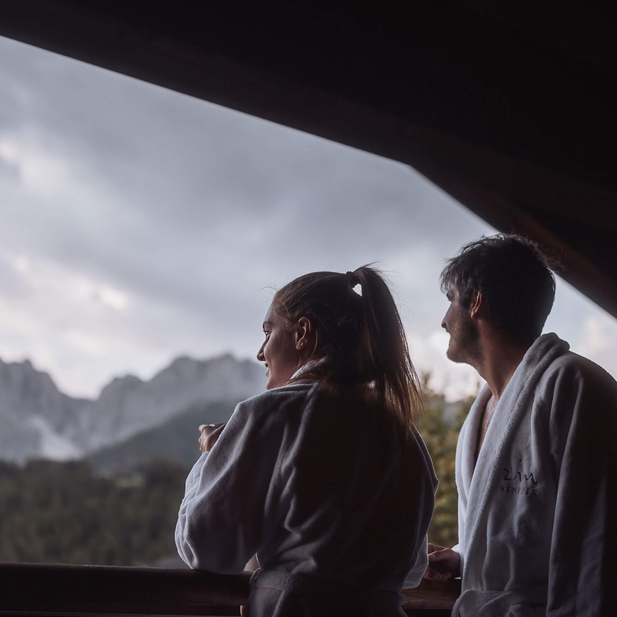 Ein Paar in Bademänteln auf dem Balkon