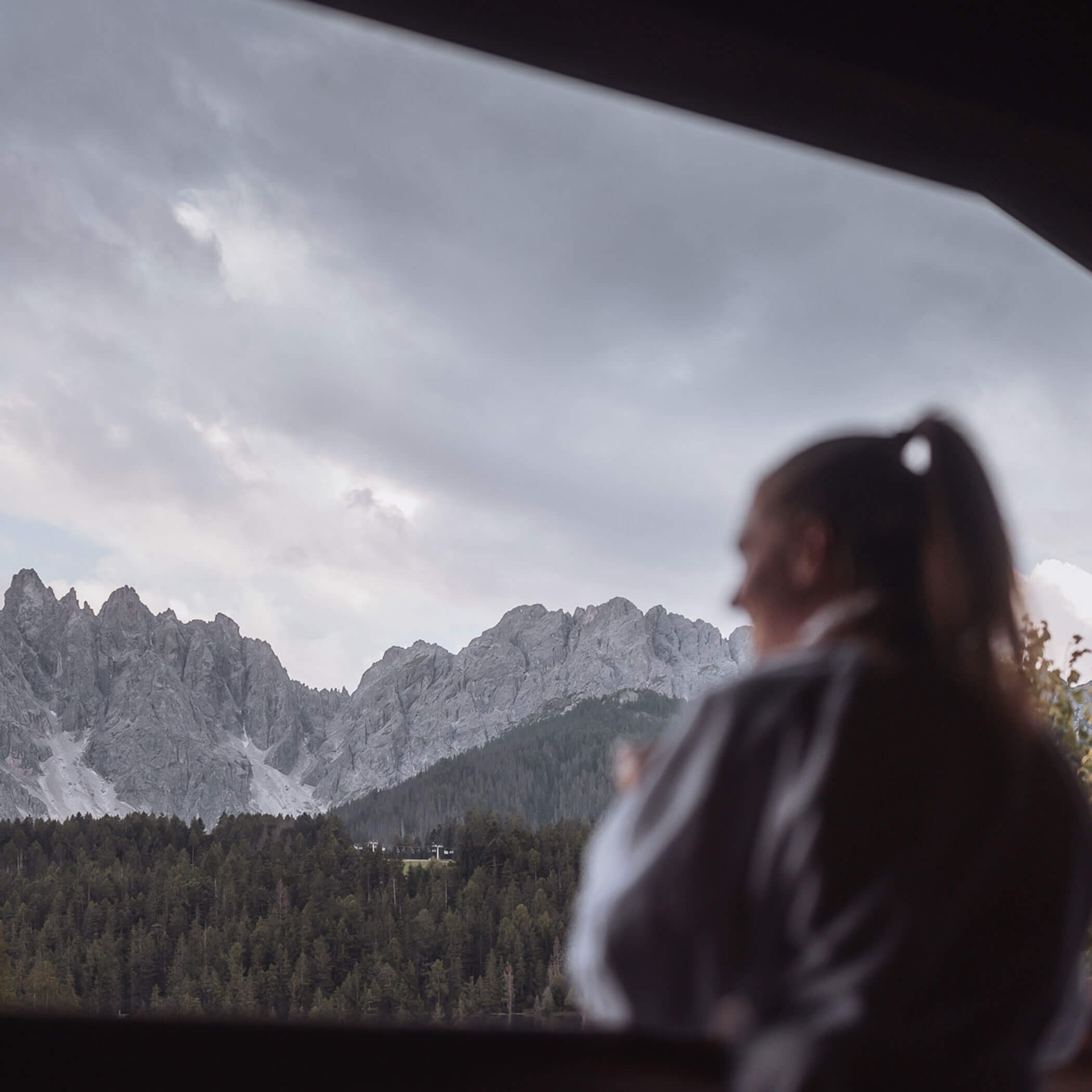 Eine Frau im Bademantel, dahinter die Dolomiten